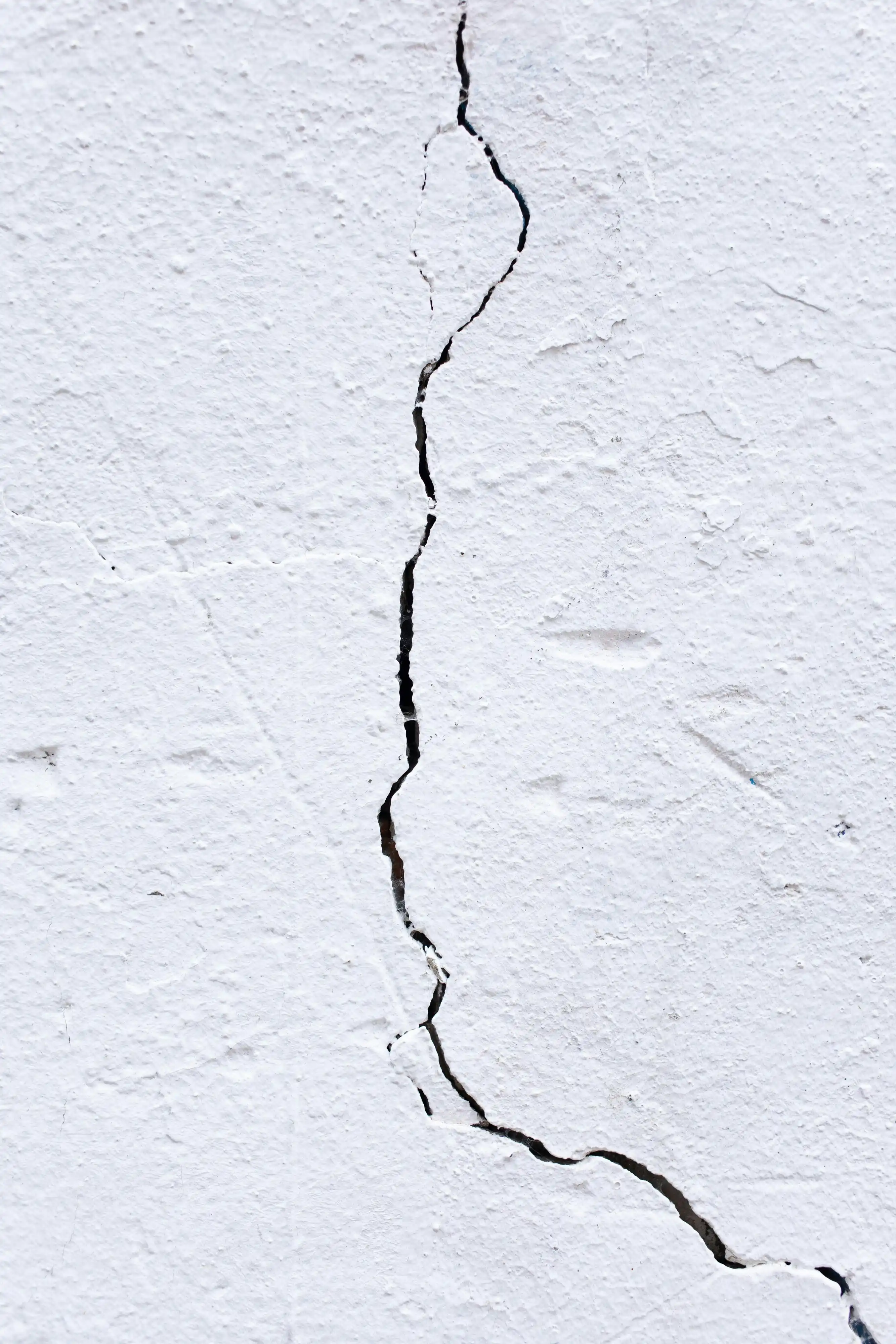 Scheur in wit crepi-pleisterwerk van een muur.